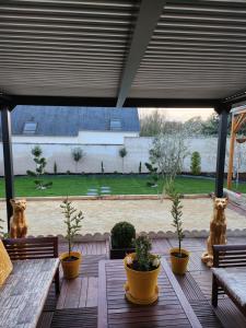 a patio with a table and potted plants at les oliviers in Veigné