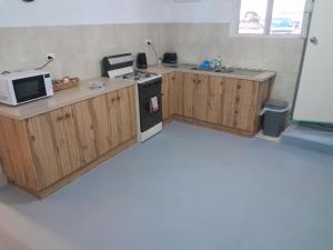 a kitchen with wooden cabinets and a microwave at Green Opal in Coober Pedy