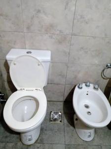 y baño con aseo y lavamanos. en Departamento 2 ambientes en La Plata