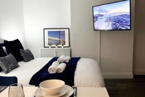 um quarto com uma cama e uma televisão na parede em Windsor Apartment em Brighton & Hove