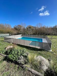 a swimming pool in the middle of a field at Casa de Campo con Bosque y Pileta in Tandil