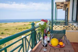 a table with a plate of fruit and a bottle of wine at Vitoratos Studios in Lixouri