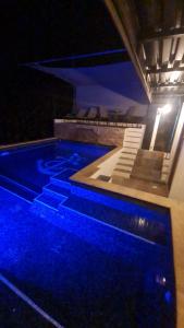 una piscina notturna con luci blu di Casa Proa a Uvita
