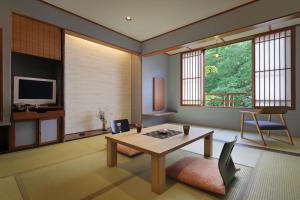 ein Wohnzimmer mit einem Tisch und einem TV in der Unterkunft Moritaya in Koriyama