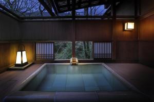 a swimming pool in a house with a lamp and a window at Moritaya in Koriyama
