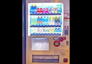 a refrigerator filled with lots of bottles of soda at Stay SAKURA Tokyo Shinjuku Hyakukura in Tokyo