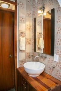 ein Badezimmer mit einem weißen Waschbecken und einem Spiegel in der Unterkunft Casa Lili in Oaxaca de Juárez