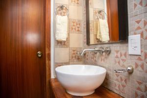 ein Badezimmer mit einem weißen Waschbecken und einem Spiegel in der Unterkunft Casa Lili in Oaxaca de Juárez