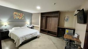 1 dormitorio con 1 cama y TV en Hotel Varadero Internacional en Guayaquil