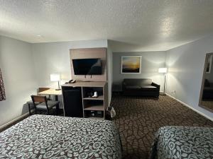 a hotel room with a bed and a desk at Baymont by Wyndham Manistee in Manistee