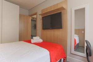 a bedroom with a bed and a flat screen tv at Lindo local a 300m da Santa Casa e Perto UFRGS - BnB Serviços Inteligentes Por Fioravante in Porto Alegre +7 photos