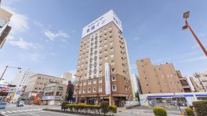 een hoog gebouw met een klok erop bij Toyoko Inn Miyazaki Chuo-dori in Miyazaki