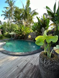 uma piscina no meio de um deque de madeira em Puri Sundaram Villa em Ubud