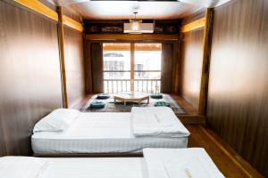 Kleines Zimmer mit 2 Betten und einem Tisch in der Unterkunft Odyssey Hostel, Tours & Motorbikes Rental in Ha Giang