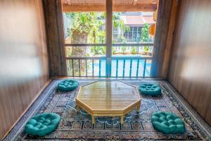 a screened in porch with a table and two stools at Odyssey Hostel, Tours & Motorbikes Rental in Ha Giang