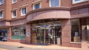出云市Toyoko Inn Izumo-shi Ekimae的一面是玻璃门的建筑