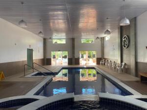 una piscina con sillas en un edificio en Hotel Cavalinho Branco, en Águas de Lindóia