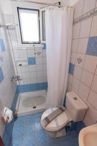 a bathroom with a toilet and a shower and a sink at Vitoratos Studios in Lixouri