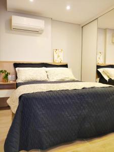 a bedroom with a large bed with a blue comforter at 20º Andar Vista Linda Próx a Santa Casa, UFRGS - BnB Serviços Inteligentes Por Fioravante in Porto Alegre