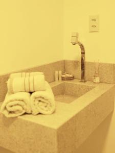 a bathroom counter with towels and a sink at 20º Andar Vista Linda Próx a Santa Casa, UFRGS - BnB Serviços Inteligentes Por Fioravante in Porto Alegre