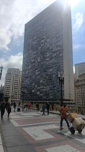 un grupo de personas caminando en frente de un edificio alto en Loft Centro Histórico: Mirante, en São Paulo