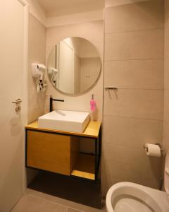 a bathroom with a sink and a mirror and a toilet at Maor Hotel in Vlorë