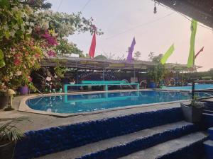 a swimming pool with blue water in a resort at Villa violeta beach resort in San Juan