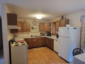 eine Küche mit einem weißen Kühlschrank und Holzschränken in der Unterkunft Kenway Ranch in Southwest Harbor