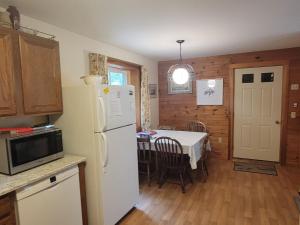 eine Küche mit einem weißen Kühlschrank und einem Tisch in der Unterkunft Kenway Ranch in Southwest Harbor