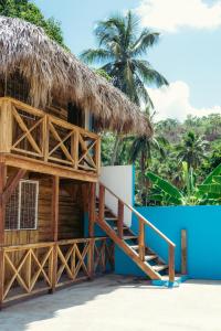 a house with a thatched roof and stairs at Parador El Ermitaño in Santa Bárbara de Samaná