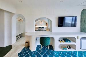 a living room with a white table and a tv at Hotel Sea Shell in Shimoda