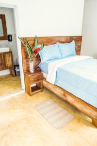 1 dormitorio con 1 cama y un jarrón de flores sobre una mesa en Parador El Ermitaño, en Santa Bárbara de Samaná