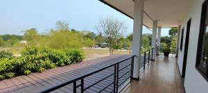 a balcony of a house with a wooden deck at Dowslom Place in Ban Phayun