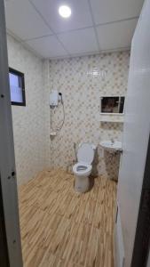 a bathroom with a toilet and a sink at Dowslom Place in Ban Phayun