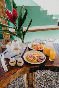 a table with two plates of food and orange juice at Parador El Ermitaño in Santa Bárbara de Samaná
