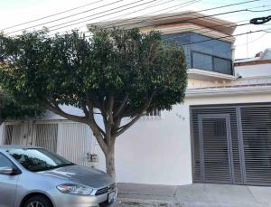 une voiture garée à côté d'un arbre devant une maison dans l'établissement Apartaestudio#7 ITESM aire acondicionado & cochera, à Laborcillas