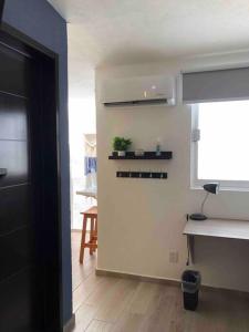 Zimmer mit einer Küche mit einer Theke und einem Tisch in der Unterkunft Apartaestudio#7 ITESM aire acondicionado sin cochera in Laborcillas