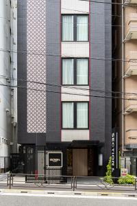 a tall black building with a sign in front of it at Section L Yushima-Ueno in Tokyo