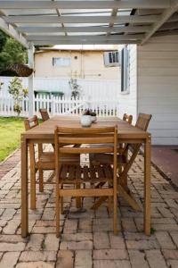a wooden table and chairs on a patio at The Hunter House c1917 in Cessnock