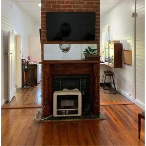 a living room with a tv on top of a fireplace at The Hunter House c1917 in Cessnock
