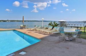 una piscina con mesas y sillas junto al agua en Compass Point 205 en Gulf Shores