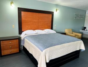 a bedroom with a large bed with a wooden headboard at Regency Inn Bald Knob in Bald Knob