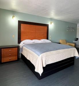 a bedroom with a large bed with a wooden headboard at Regency Inn Bald Knob in Bald Knob