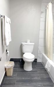 a bathroom with a toilet and a tub and a sink at Regency Inn Bald Knob in Bald Knob