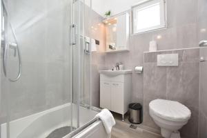 a bathroom with a shower and a toilet and a sink at Apartments Zorana in Rogoznica +52 photos