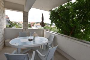 a white table and chairs on a balcony at Apartments Zorana in Rogoznica