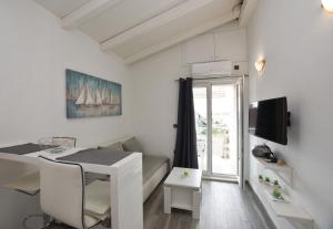 a small white room with a desk and a bed at Apartments Zorana in Rogoznica
