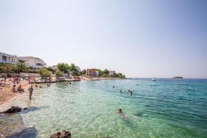 a group of people in the water at a beach at Apartments Zorana in Rogoznica