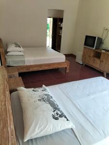 a room with two beds and a tv in it at Nirwana Sea Side Cottages in Lovina