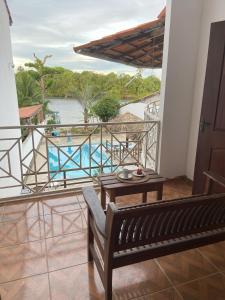 balcón con banco y vistas a la piscina en Casa do Professor Hostel, en Barreirinhas